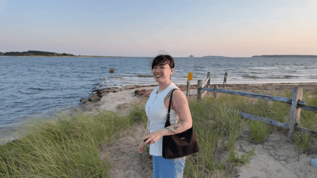 a girl in front of a beach during sunset